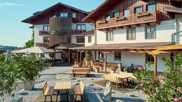 Traditionelles Hotel im bayerischen Stil mit Holzbalkonen und Außenbereich mit Sitzplätzen